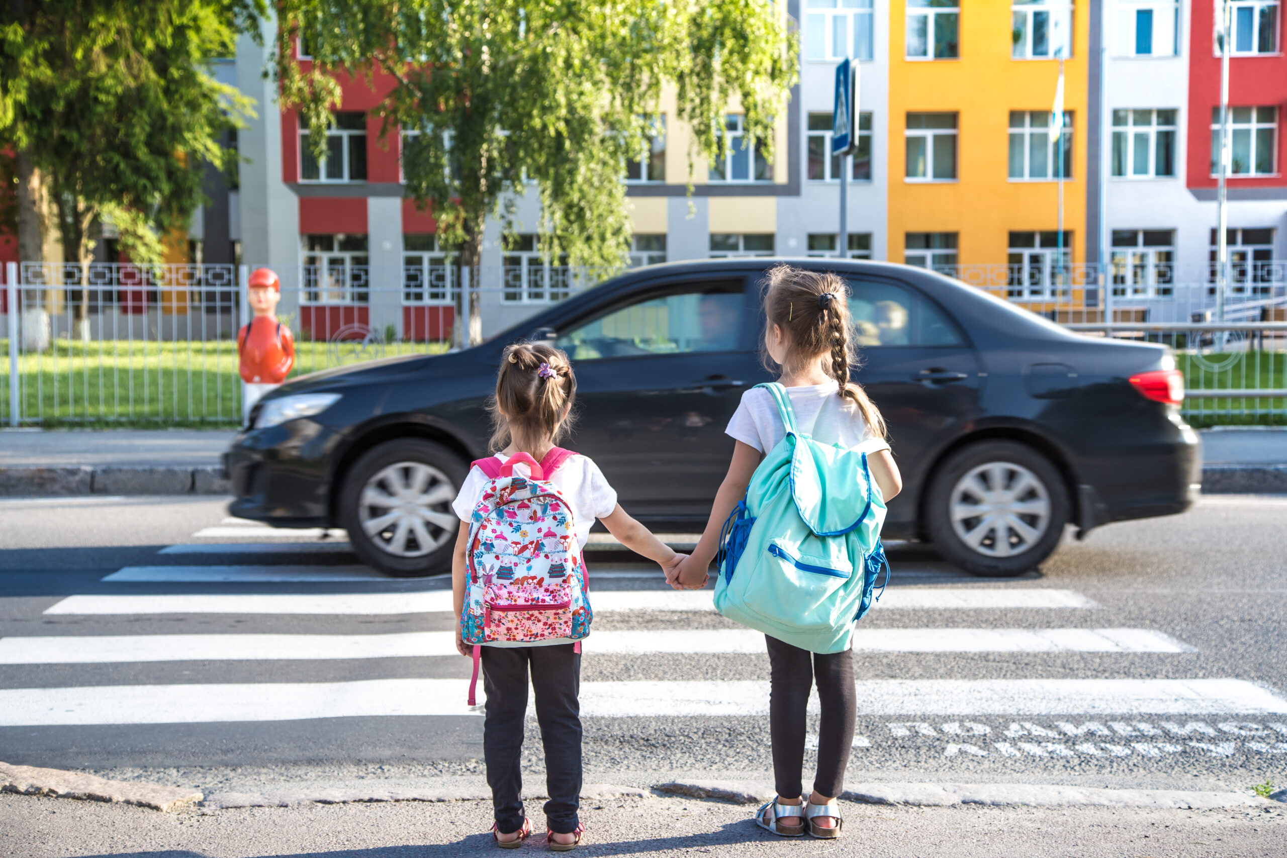 back school education concept with girl kids elementary students carrying backpacks going class scaled