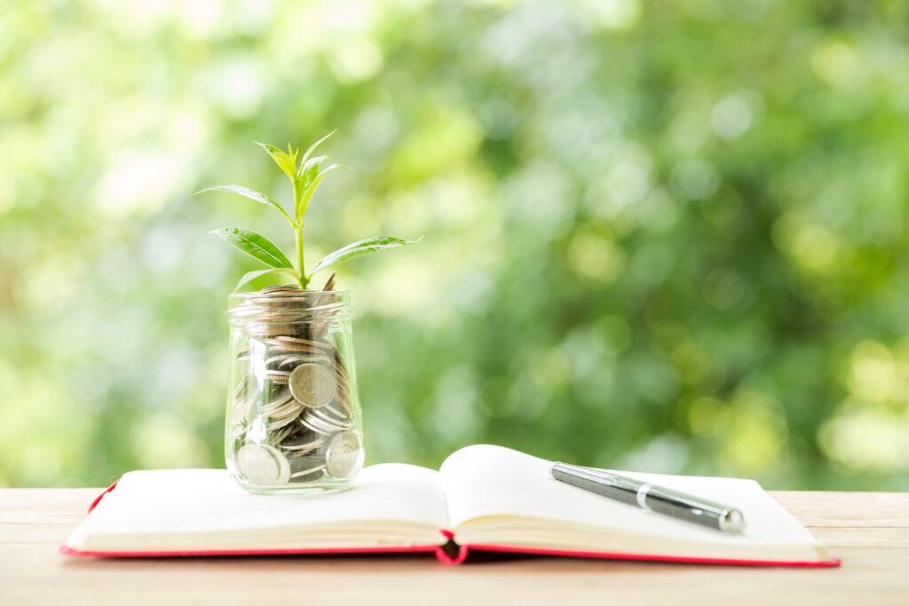 plant growing from coins glass jar blurred nature